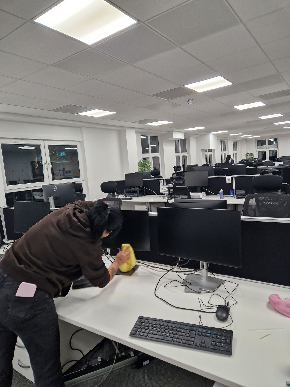 Office cleaning in Dublin: an Ecoleen cleaner wiping down desks in an open-plan office after working hours